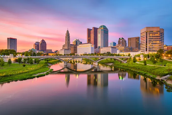 A panoramic view of downtown Columbus, Ohio, with the city skyline and Scioto River.